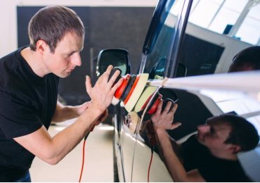 Polishing a car body with sandpaper